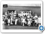 Fancy dress party c1924-25 held in the "Comrades Hut" Neil Wilson (in sailor suit) with his sister Peggy. Hannah Alexander (nee Mackenzie) middle towards right in tall white hat dressed as Wills cigarette.